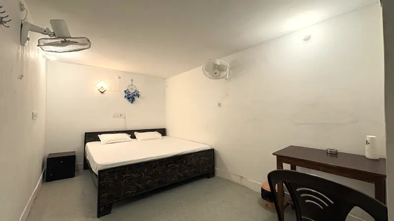 Room 2 with bed, desk and wall fans